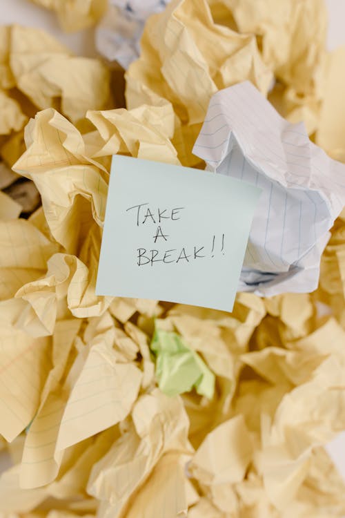 Free Sticky note with 'Take a Break' on crumpled paper background. Stock Photo